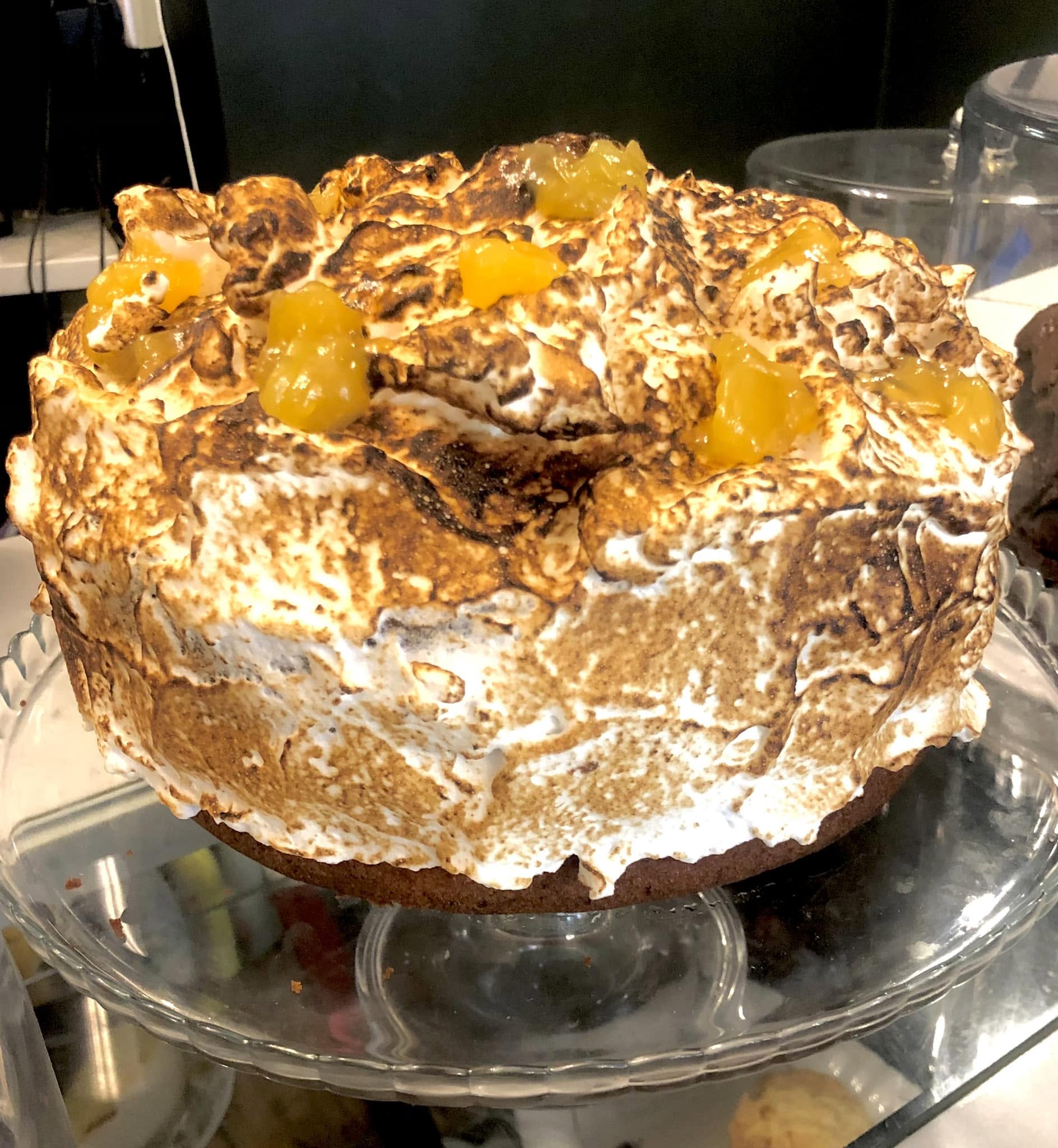 Petit Fi's lemon meringue cake with toasted peaks on a glass cake stand